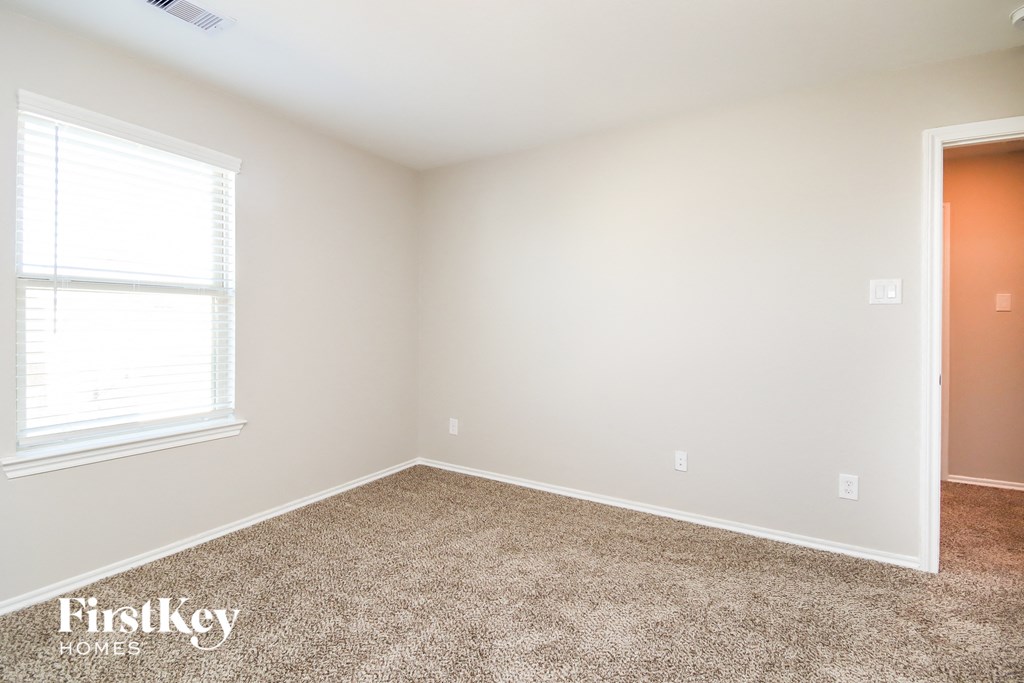 a room with carpet and a window and a door
