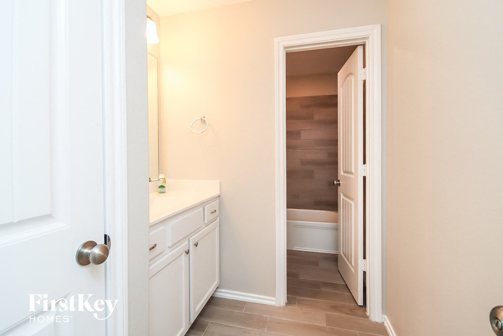 a small bathroom with a sink and a toilet and a hallway with a staircase