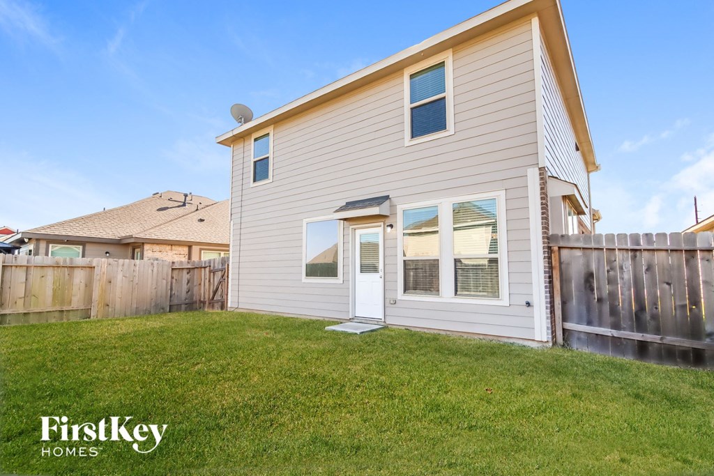 a white house with a backyard and a wooden fence