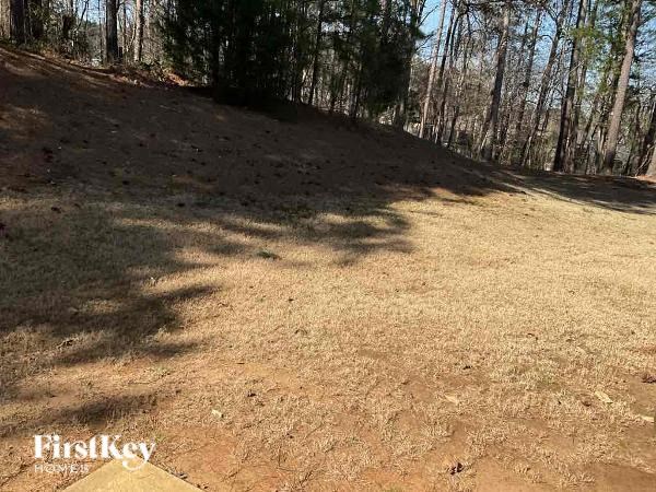 A grassy hill with trees in the background and the words "FirstKey Home" on the bottom left.