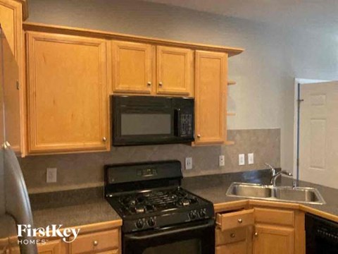 A kitchen with wooden cabinets and a black stove top oven.
