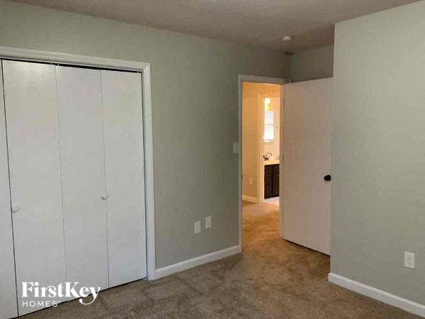 an empty room with a closet and a door to a bathroom
