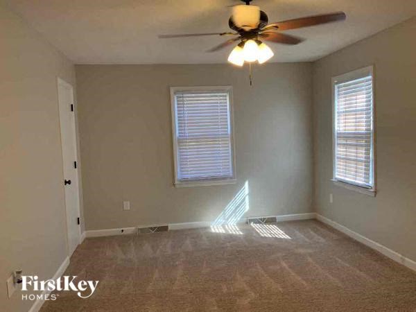an empty room with a ceiling fan and a window