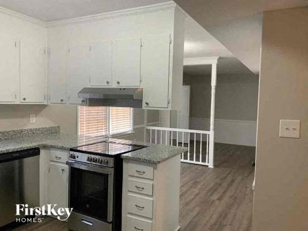 a kitchen with white cabinets and a stove top oven
