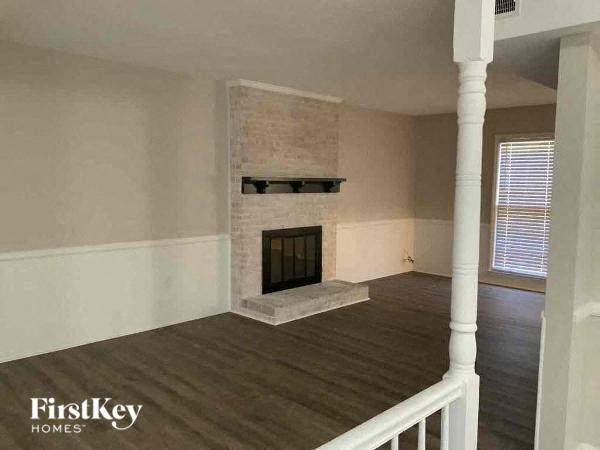 a living room with a fireplace and a wooden floor