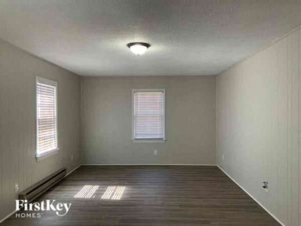 an empty room with wood floors and a light on the ceiling