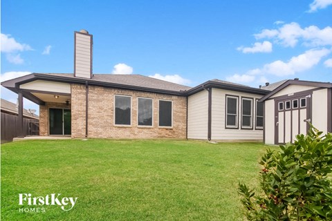 a home with a grassy yard and a house