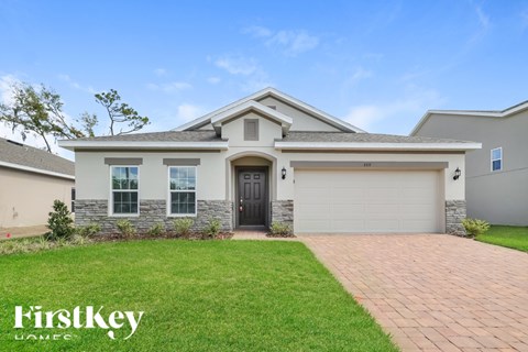 A house with a garage and a driveway in front of it.