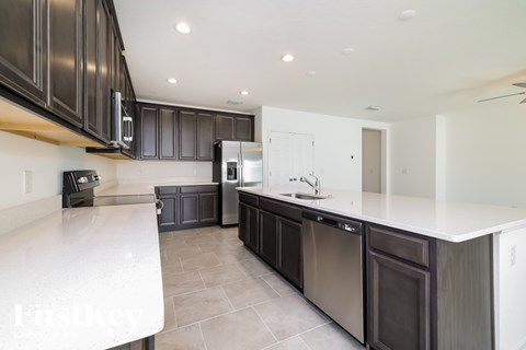 A modern kitchen with dark brown cabinets and stainless steel appliances.