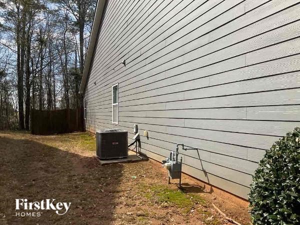 the side of a house with a microwave on the ground