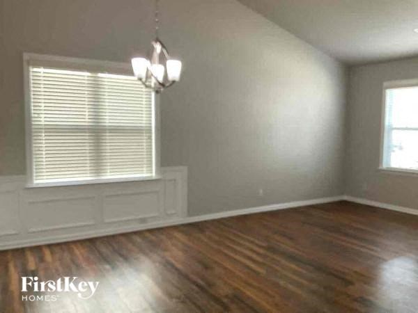 an empty living room with a large window and wood floors