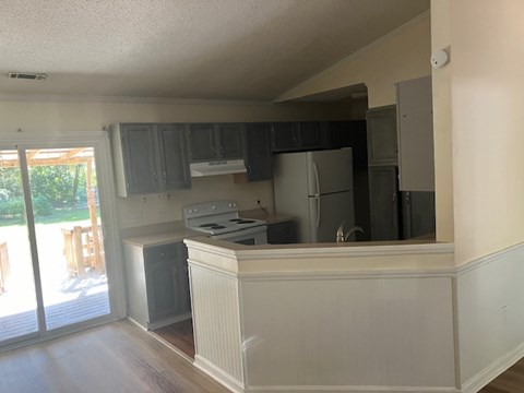 A kitchen with a stove top oven and a refrigerator.