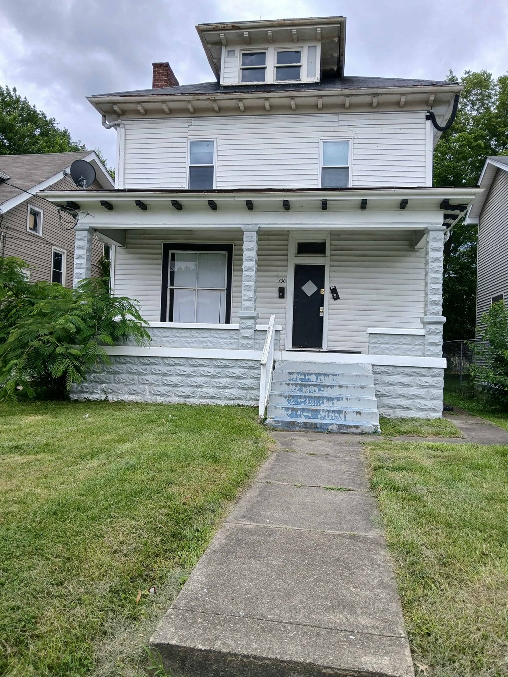 a white house with a sidewalk in front of it
