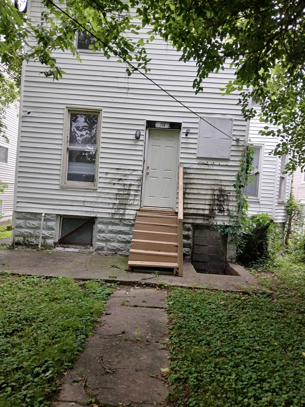 the back of a white house with a white door and stairs