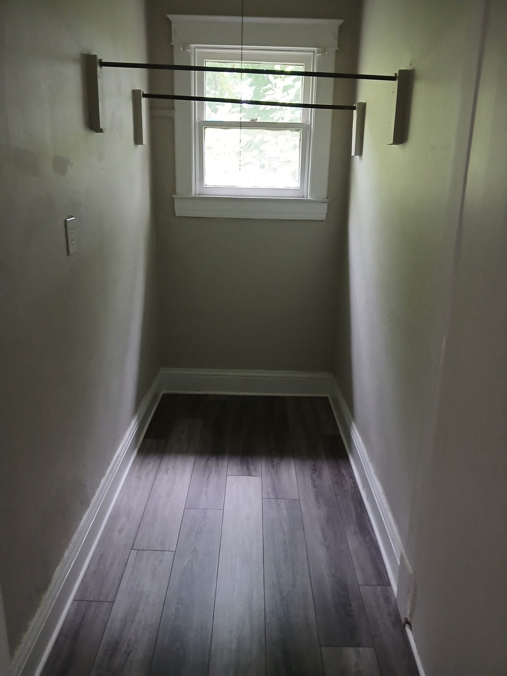 a empty room with a window and a wooden floor