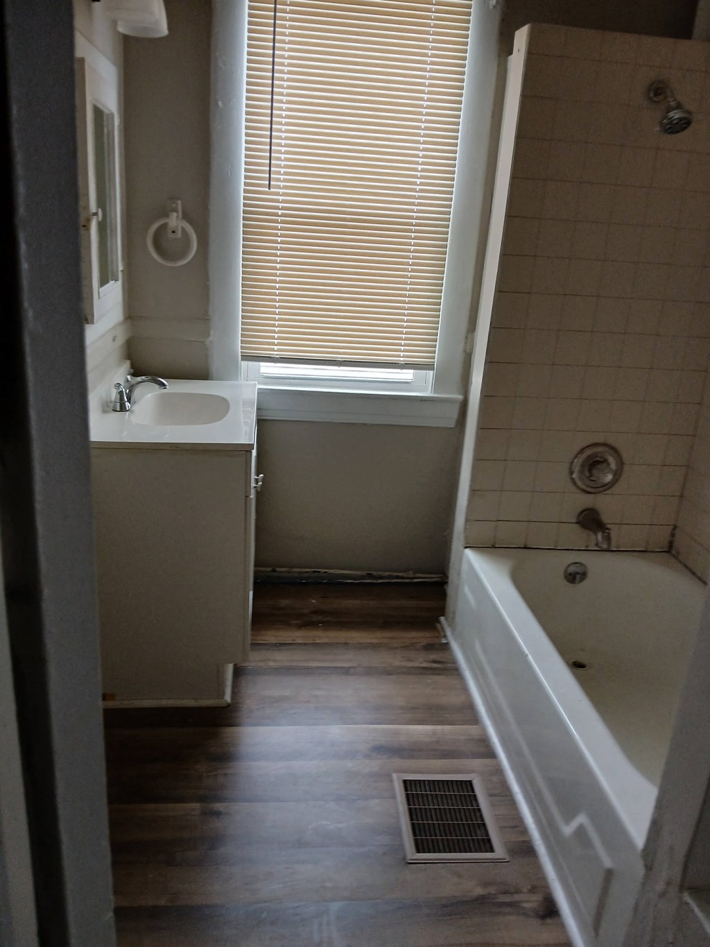 a small bathroom with a tub and a sink and a window