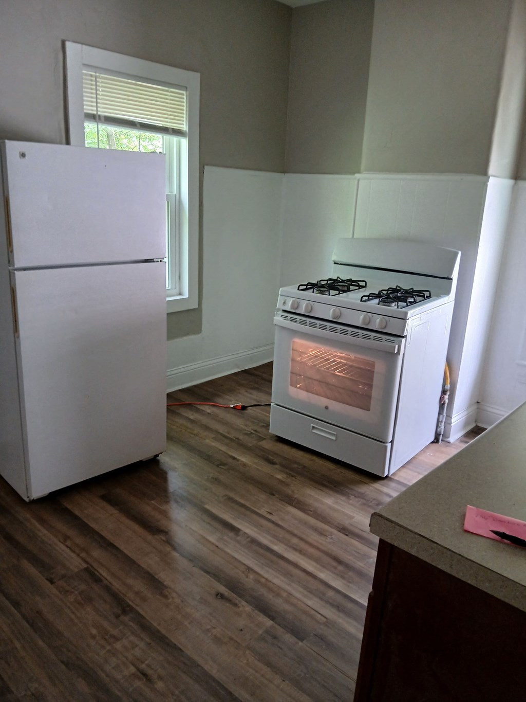 an empty kitchen with a stove and a refrigerator