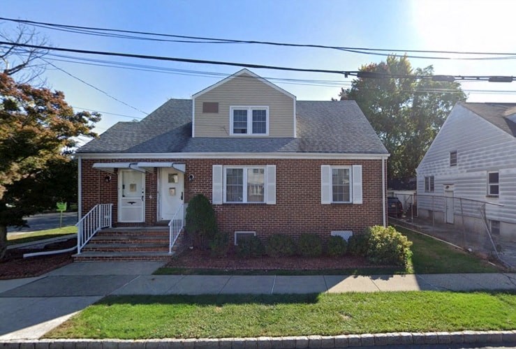 a brick house with white windows and a white front door