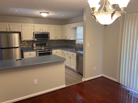 A kitchen with a blue counter top and white cabinets.