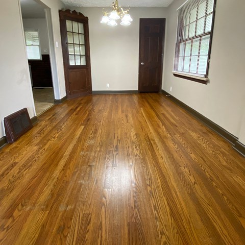 a living room with a hard wood floor and a door