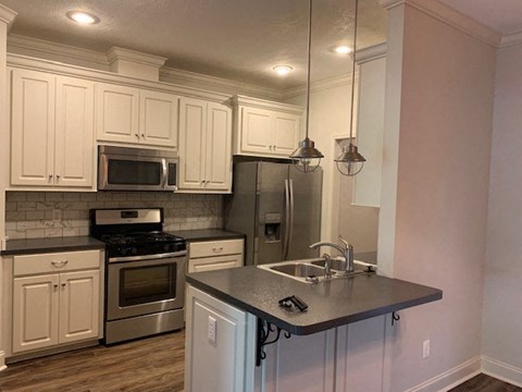 A kitchen with white cabinets and a black stove top oven.