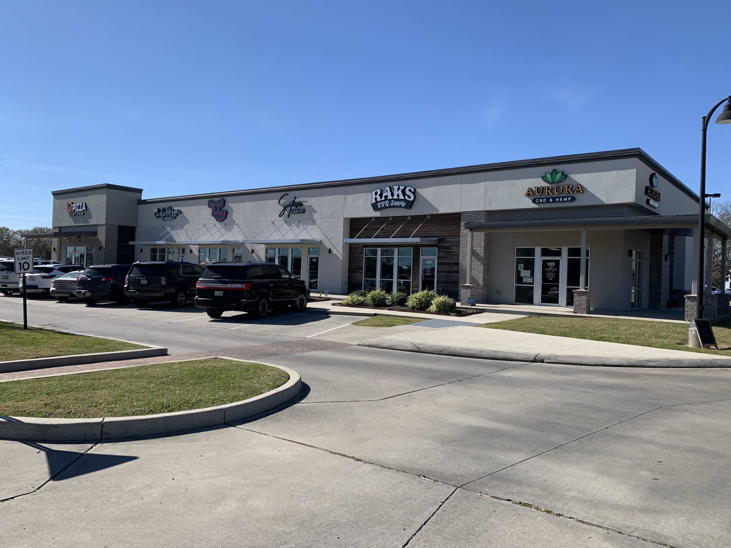 a shopping center with cars parked in front of it