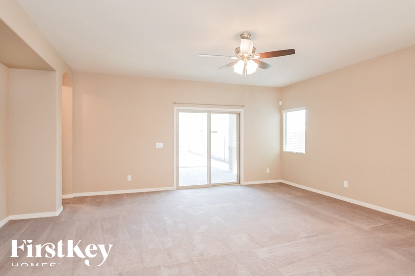 A spacious room with a ceiling fan and sliding glass doors.