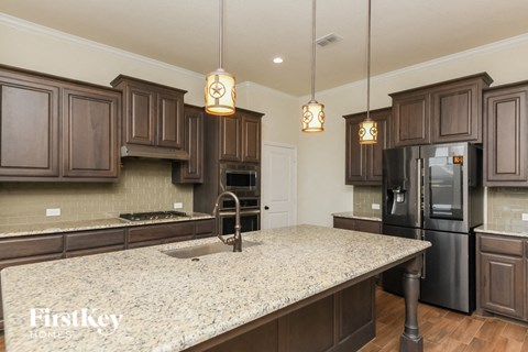 a kitchen with a large island and a black refrigerator