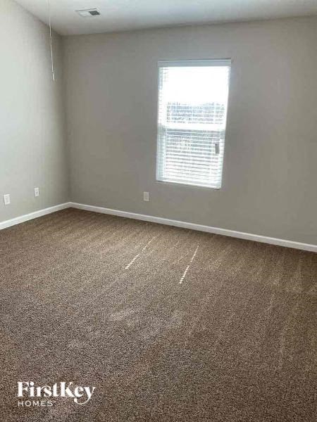 an empty room with carpet and a window