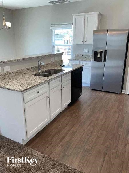 a kitchen with white cabinets and a stainless steel refrigerator