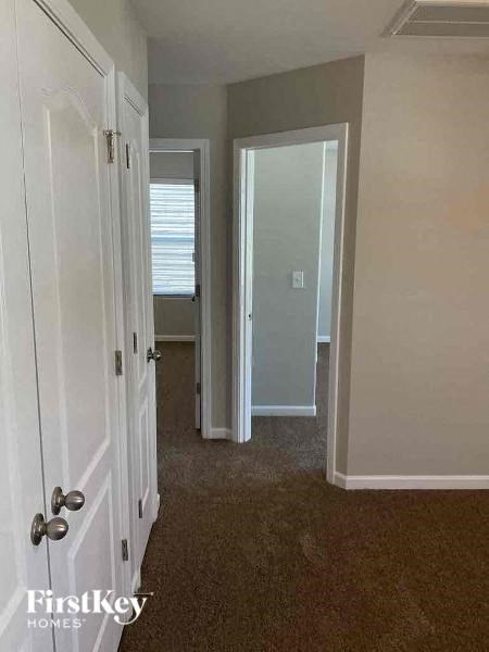 a hallway with a door to a bedroom and a closet