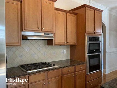 a kitchen with wooden cabinets and a stove and oven