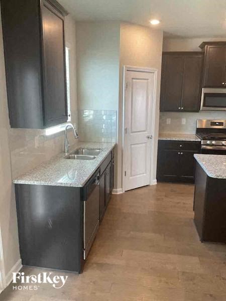 a kitchen with black cabinets and a sink and a door