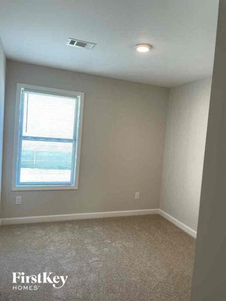 an empty room with a window and a carpet