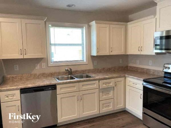 a kitchen with white cabinets and a stove and a sink