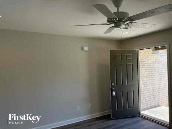an empty room with a ceiling fan and a door