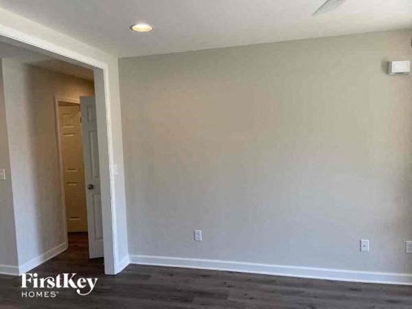 an empty living room with white walls and a door to a hallway