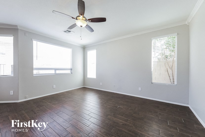 A room with a ceiling fan and wooden flooring.