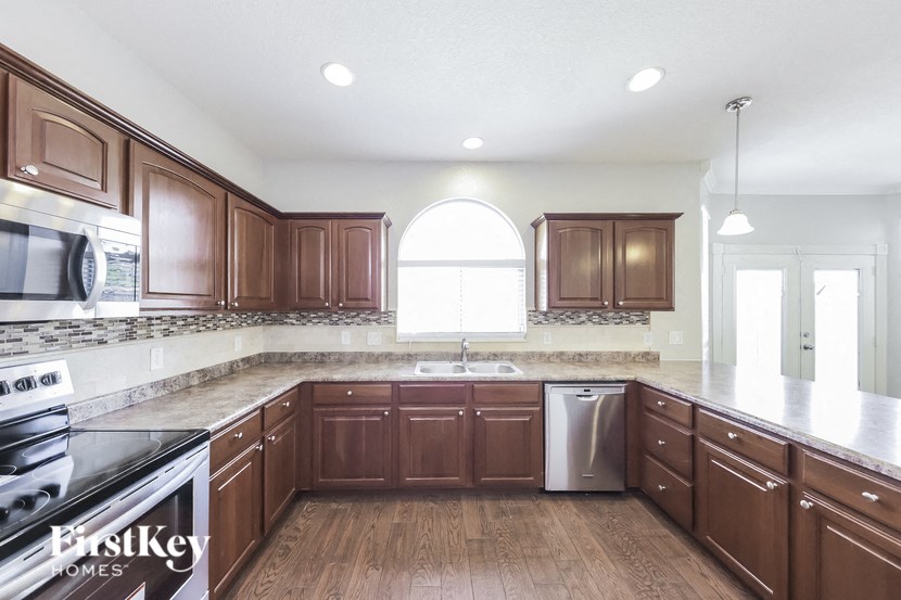 A kitchen with wooden cabinets and a stainless steel dishwasher.