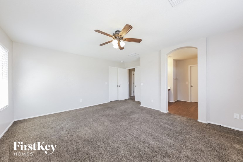 A spacious room with a ceiling fan and carpeted floor.