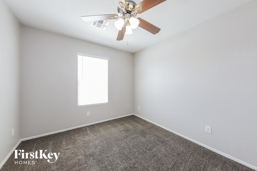 A room with a ceiling fan and a window.