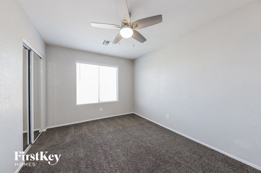 A spacious room with a ceiling fan and a window.