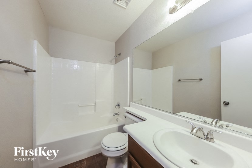 A white bathroom with a toilet, sink, and shower.