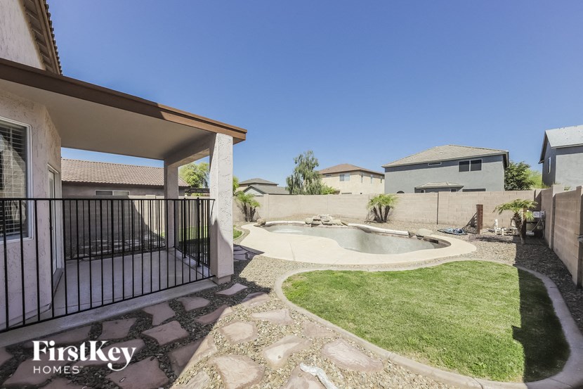 A backyard with a pool and a patio area.