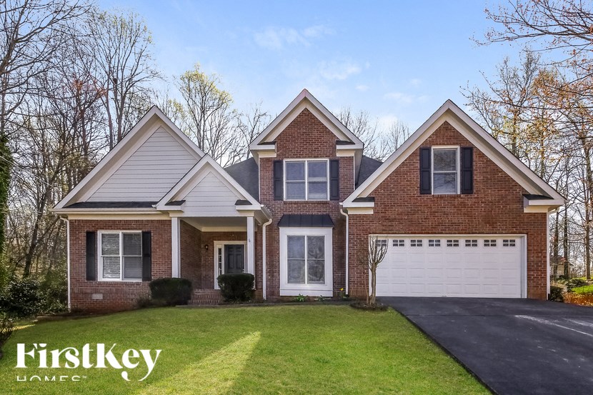 a brick house with a white garage door and a lawn
