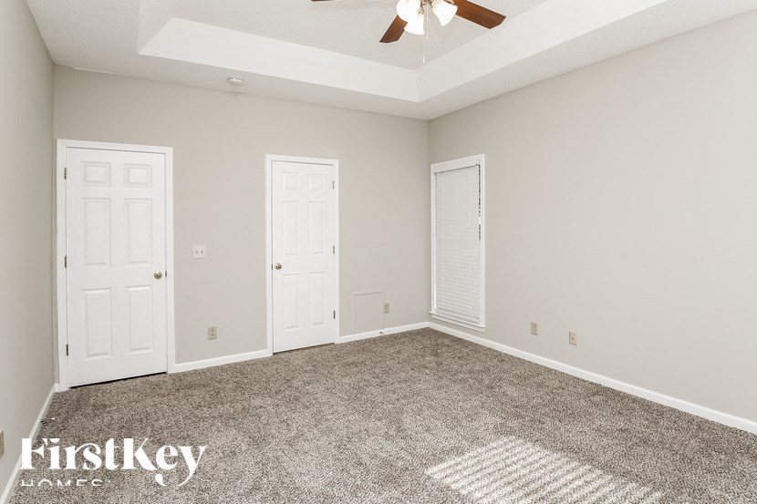 a empty room with two doors and a ceiling fan
