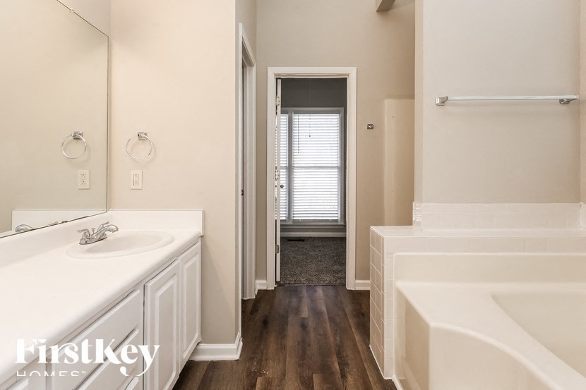 a bathroom with a tub and a sink and a mirror