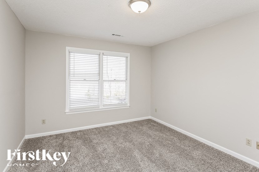 a bedroom with a carpeted floor and a window