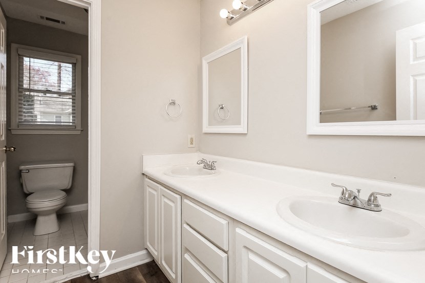 a bathroom with two sinks and a toilet