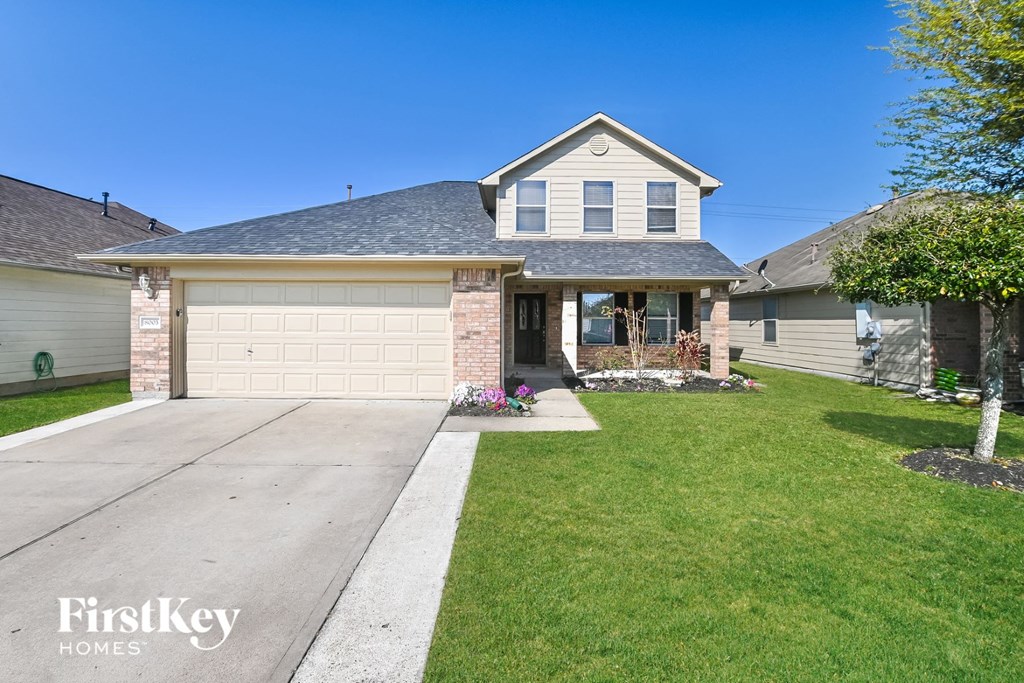 A house with a garage and a driveway in front.